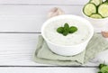 Indian raita sauce with dahi yogurt, cucumber and herbs on a white wooden background. copy space. Greek tzatziki sauce. Royalty Free Stock Photo