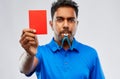 Indian referee whistling and showing red card