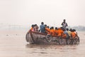 Indian rower man training his orange cloth rower men on the boat that floating over the Ganges Ganga river in Varanasi.