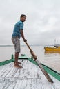 Indian rower with a paddle, standing on the boat that floating over the Ganges Ganga river in Varanasi, Uttar Pradesh, India