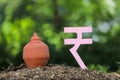 Indian rupees symbol and clay piggy bank