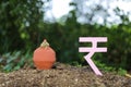 Indian rupees symbol and clay piggy bank