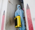 An Indian sanitary worker in a protective suit conducting disinfection of a school during COVID-19