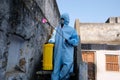 An Indian sanitary worker in a protective suit conducting disinfection of a school during COVID-19