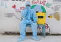 Indian sanitary worker in a protective suit conducting disinfection of a school during COVID-19
