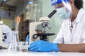 Indian Scientist man look into Microscope research in science laboratory. Asian biochemistry scientist using microscope in Royalty Free Stock Photo