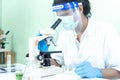 Indian Scientist man look into Microscope research in science laboratory. Asian biochemistry scientist using microscope in Royalty Free Stock Photo