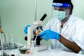 Indian Scientist man look into Microscope research in science laboratory. Asian biochemistry scientist using microscope in Royalty Free Stock Photo