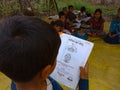 indian scool boy reading book magic of mathematics at open area class village about laptop system in India January 1, 2020