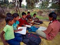 indian children studying at open area class village about laptop system in India January 1, 2020