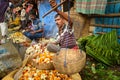 Indian seller weighs flowers by scales on Flower market at Mallick Ghat in Kolkata. India