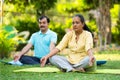 Indian senior couple doing meditation or yoga at park - concept of healthy lifestyle, mental wellness and self acre. Royalty Free Stock Photo