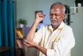 indian senior old man exercising by strenching hand due to elbow joint pain at home - concept of suffering joint pain Royalty Free Stock Photo