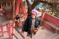 Indian senior in turban rises up the steps to hindu temple