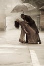 Indian smartly dressed couple dancing under an umbrella in the rain. Royalty Free Stock Photo