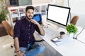 Indian smiling businessman sitting in comfortable chair in front of computer monitor and relaxing after hard work at office Royalty Free Stock Photo