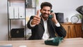 Indian smiling businessman talking on wired vintage telephone of 80s, says hey you call me back Royalty Free Stock Photo