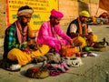 An Indian Snake charmer wearing a turban charms or hypnotizes a cobra using pungi flute at Assi ghat Royalty Free Stock Photo