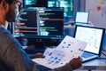 Indian software development working on coding computer screen and flowchart at night in modern office