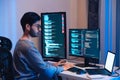 Indian software development working on coding computer screen and flowchart at night in modern office