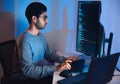 Indian software development working on coding computer screen and flowchart at night in modern office