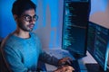Indian software development working on coding computer screen and flowchart at night in modern office