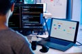 Indian software development working on coding computer screen and flowchart at night in modern office