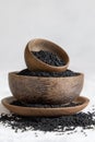 Indian spice Black cumin nigella sativa or kalonji seeds in wooden bowls on white table close up