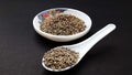 indian spice cumin seeds in bowl and spoon isolated on black background Royalty Free Stock Photo