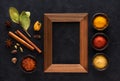 Indian spices and empty wooden frame for text on black concrete background Royalty Free Stock Photo