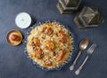 Indian spicy Chicken Tikka Biryani with raita and gulab jamun Served in a dish top view on grey background