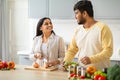 Indian Spouses Having Conversation While Preparing Food In Cozy Kitchen Royalty Free Stock Photo