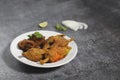 snacks Red Chilli Pakora served in a White ceramic plate with coriander, lemon and onion Royalty Free Stock Photo