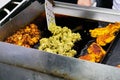 Indian street food vendor frying different tyes of meat items on a pan