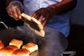 Indian street food vendor making pav baji or vada pav