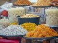 Indian Street Food vendor selling Indian local snacks and sweet cookies, sonpapdi and sugary soft candy agra ka petha.