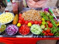 Indian street food vendor selling spicy gram chole mixture garnished with freshly cut onion,cucumber chilli and tomatoindian