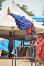 Indian Street Performer Girl Performing Aerobatics Balancing on tables with head down and feet in air