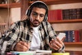 Indian Student Guy Using Smartphone Learning In University Library