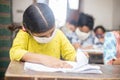 Indian Students wearing face masks sitting with social distancing at a classroom as school reopen during covid19 pandemic,