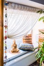 Indian style of interior with buddha boho pillowcases and white curtain