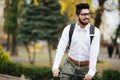 Indian stylish bearded student man with backpack with bicycle walking on street Royalty Free Stock Photo