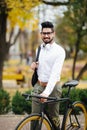 Indian stylish bearded student man with backpack with bicycle walking on street Royalty Free Stock Photo