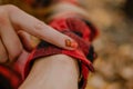 Indian summer, autumn mood. Close up ladybug on a female hand with trend fall manicure on yellow leaves background Royalty Free Stock Photo