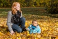 Indian summer: Young woman with her baby in autumn. Family concept for single parent.
