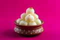 Indian Sweet or Dessert - Rasgulla, Famous Bengali sweet in clay bowl on a pink background