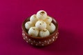 Indian Sweet or Dessert - Rasgulla, Famous Bengali sweet in clay bowl on a pink background