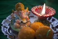 Indian sweet laddu with a prayer lamp and Ganesha statue