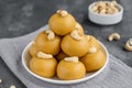 Indian sweets Besan Laddu or Laddoo on a plate on a concrete bacground. Roasted chickpea flour with ghee and sugar. Selective Royalty Free Stock Photo