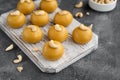 Indian sweets Besan Laddu or Laddoo on a wooden board on a concrete bacground. Roasted chickpea flour with ghee and sugar. Royalty Free Stock Photo